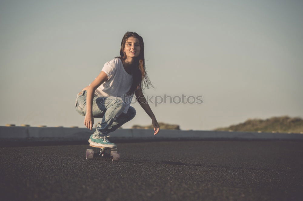 Similar – Happy female riding skate board in street