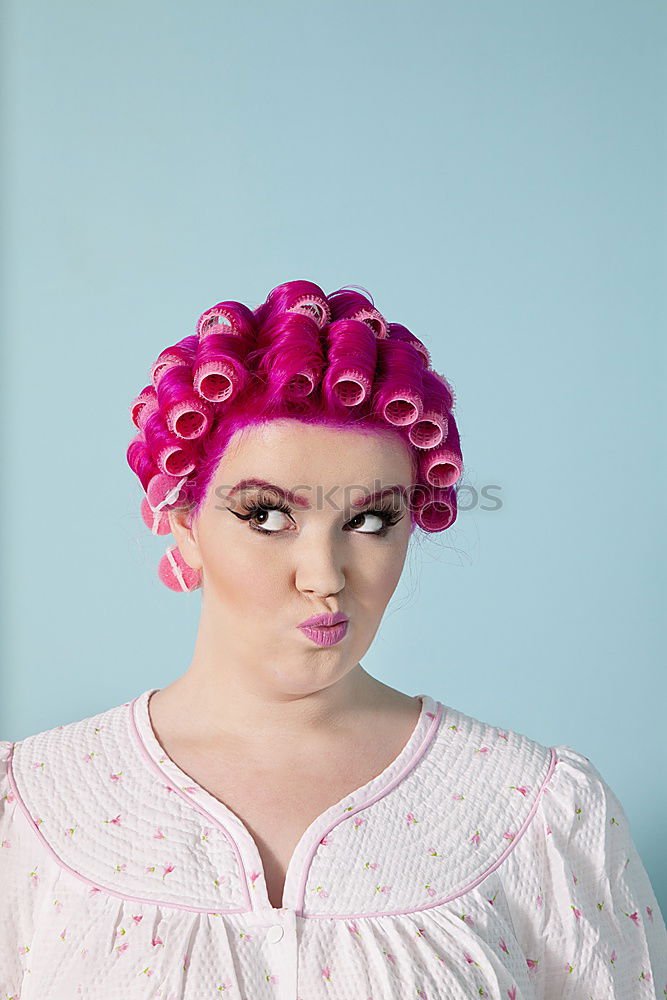 Young woman with pink hair is holding colorful lollipops