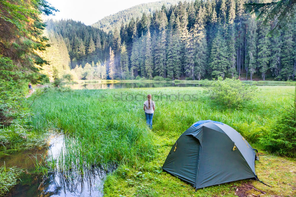 Image, Stock Photo Young woman near green tent and forest lake