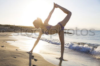 Caucasian blonde woman practicing yoga in the beach