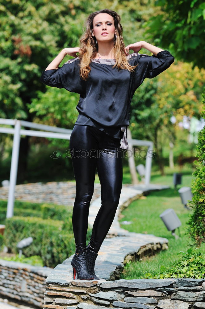 Similar – Young, very athletic woman with six pack stands barefoot on a wooden bridge in the forest and holds one leg stretched over her head