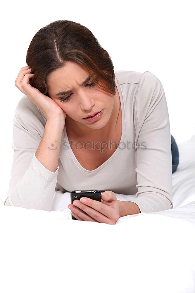 Similar – Young girl looking at mobile phone while sitting on bed