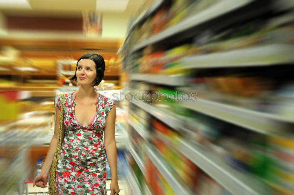 Similar – Image, Stock Photo A smiling middle aged woman in a light blue shirt is standing in a household section of a supermarket. She is holding a tablet and a red shopping basket in her hands. A woman is looking at the shelves, searching for something particular