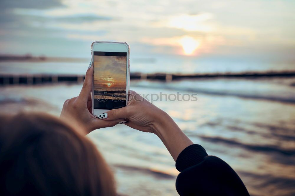 Similar – Image, Stock Photo Young woman is holding smartphone in her hands at the beach