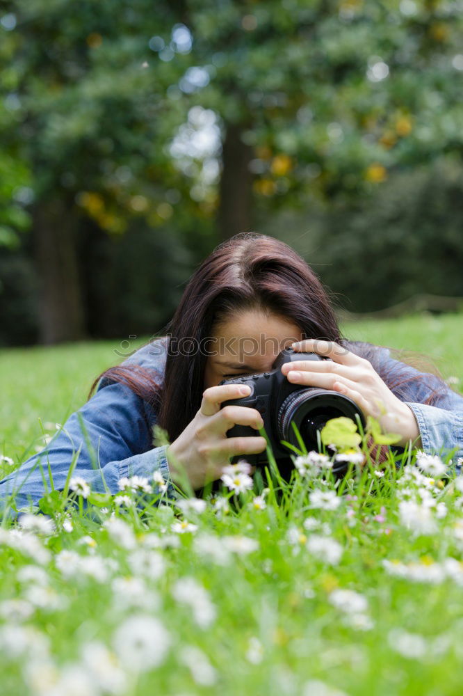 Similar – Smiling young woman using a camera to take photo at the park.