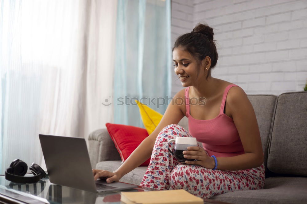 Similar – african happy woman lying on couch with laptop