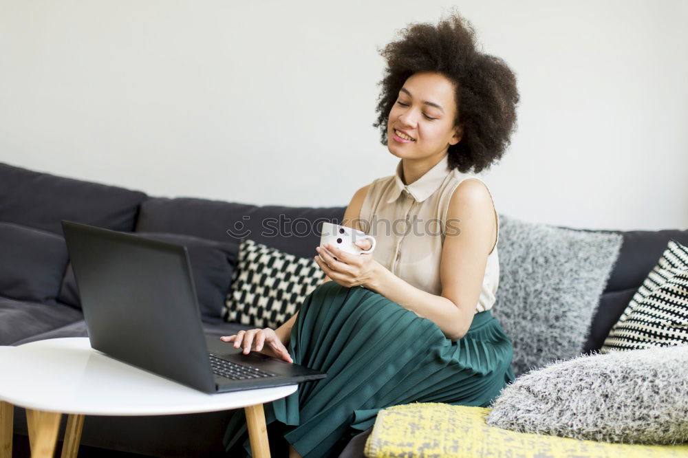 Similar – african happy woman lying on couch with laptop