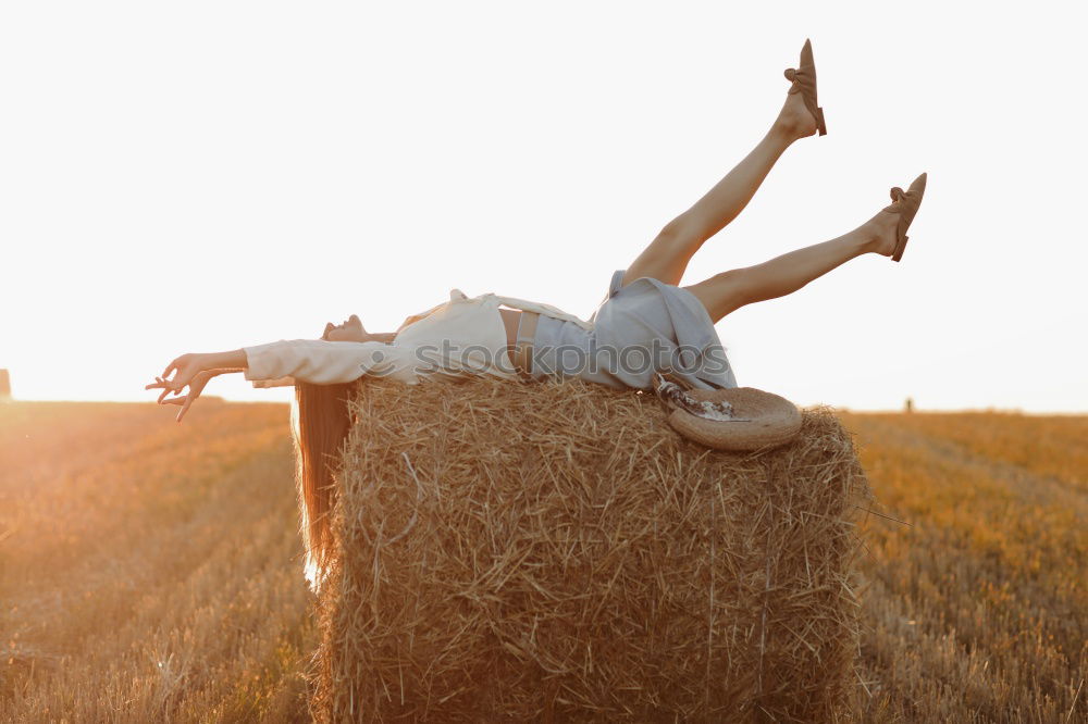 Woman in big round hat in middle of wheat field