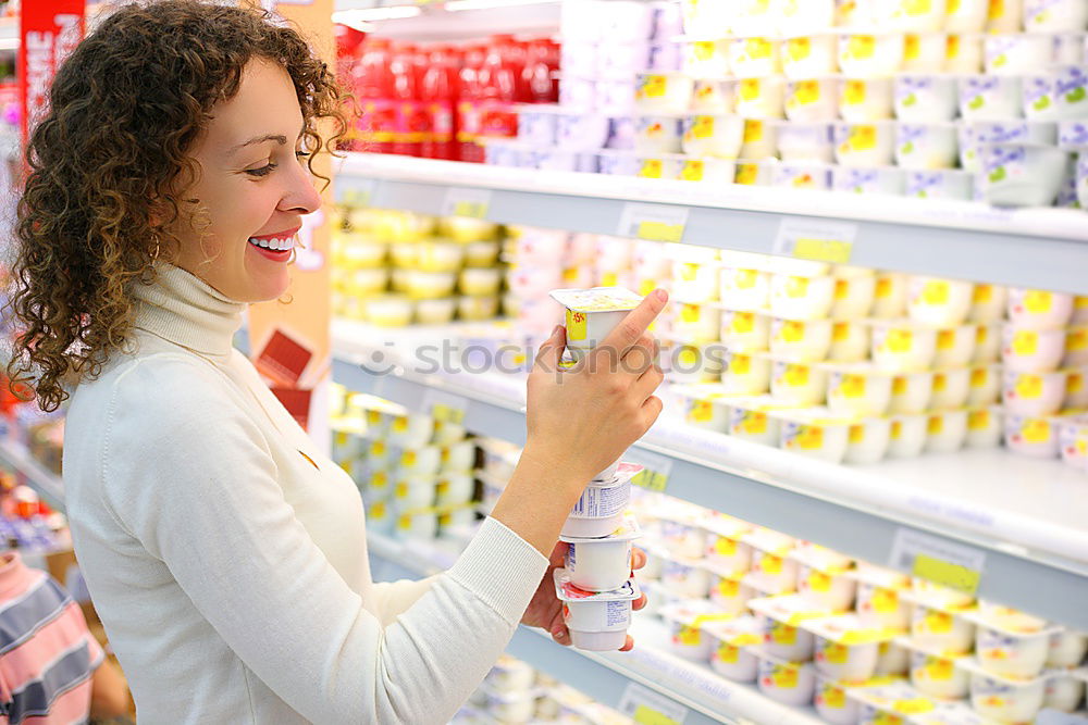 Similar – Image, Stock Photo A smiling middle aged woman in a light blue shirt is standing in a household section of a supermarket. She is holding a tablet and a red shopping basket in her hands. A woman is looking at the shelves, searching for something particular